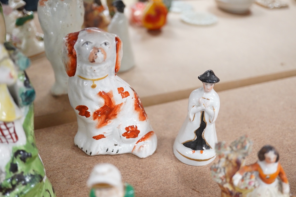 A collection of 19th century and later Staffordshire figures, mostly figural examples, including a pair a rare pair of porcelain seated figures with rabbits and a candle extinguisher, largest 15cm high (15)